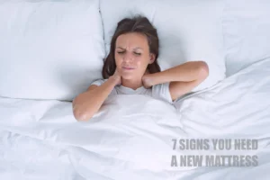 Woman waking up in pain holding her neck, illustrating the 7 signs you need a new mattress