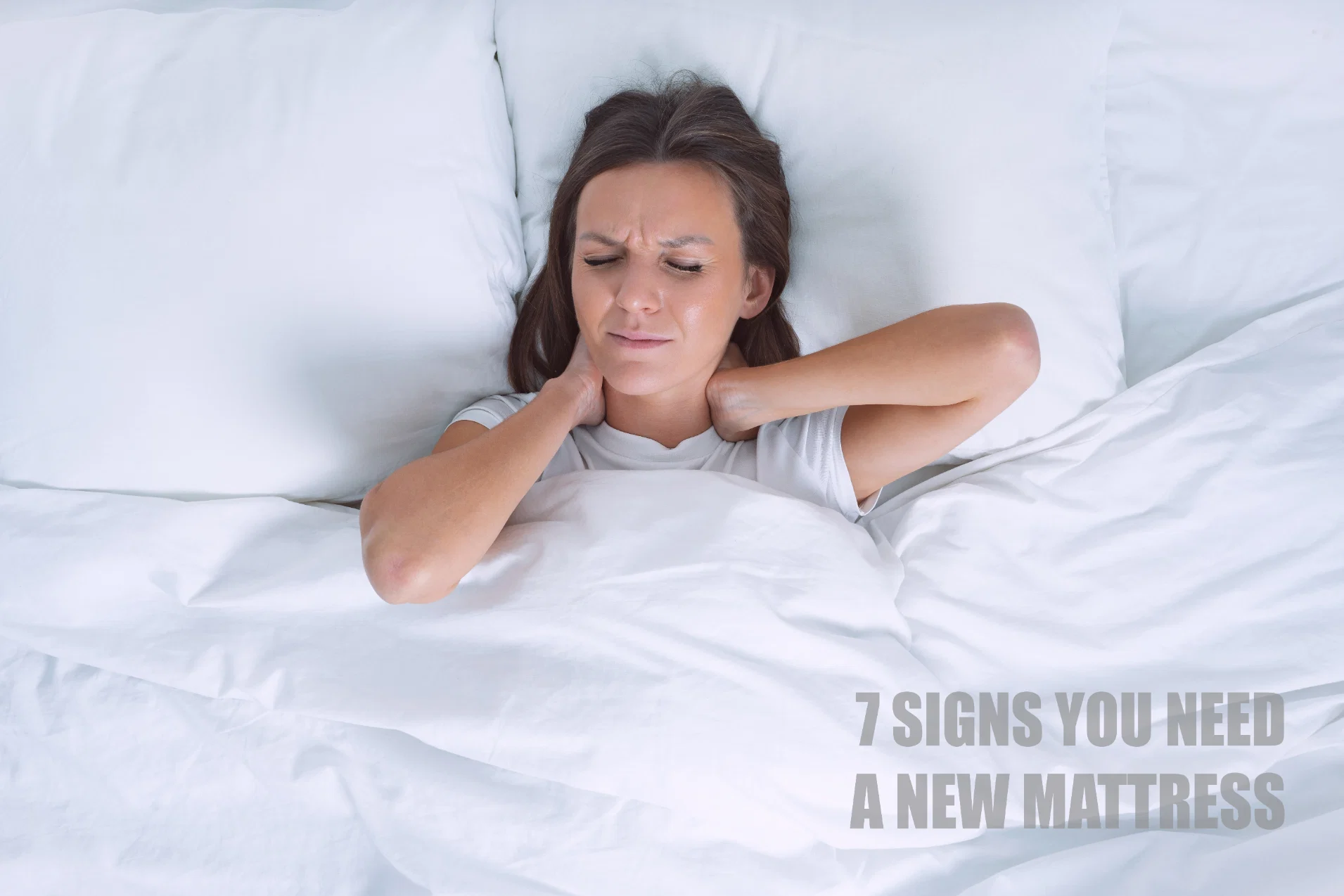 Woman waking up in pain holding her neck, illustrating the 7 signs you need a new mattress