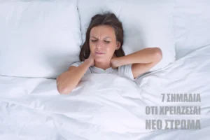 Γυναίκα που ξυπνά με πόνο κρατώντας τον αυχένα της, απεικονίζοντας τα 7 σημάδια ότι χρειάζεσαι νέο στρώμα