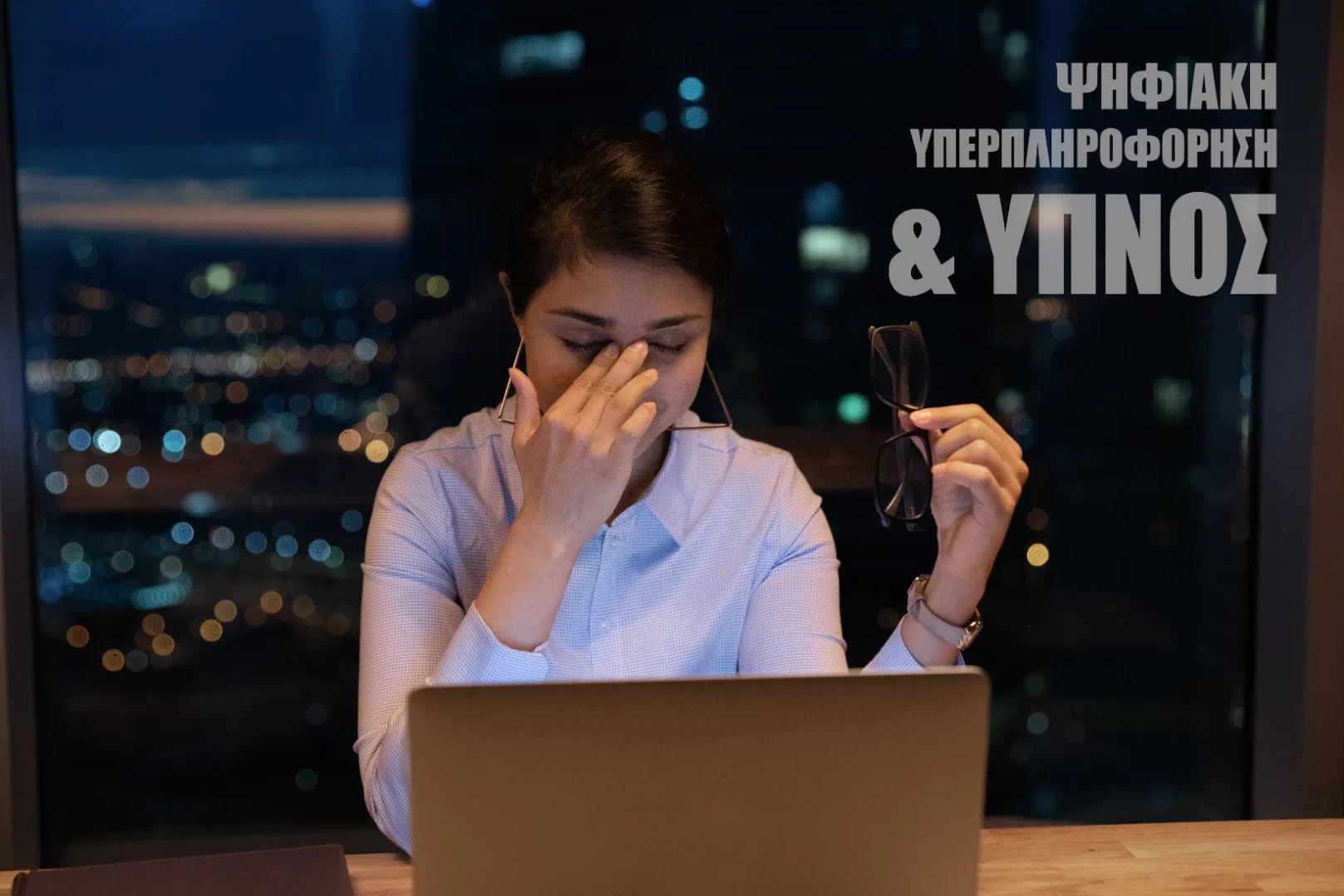 Γυναίκα που τρίβει τα μάτια της από ψηφιακή κόπωση αργά τη νύχτα μπροστά σε laptop, απεικονίζοντας πώς η υπερπληροφόρηση επηρεάζει τον ύπνο